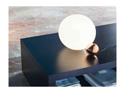 Lysande Copycat lampa från flos på ett svart soffbord